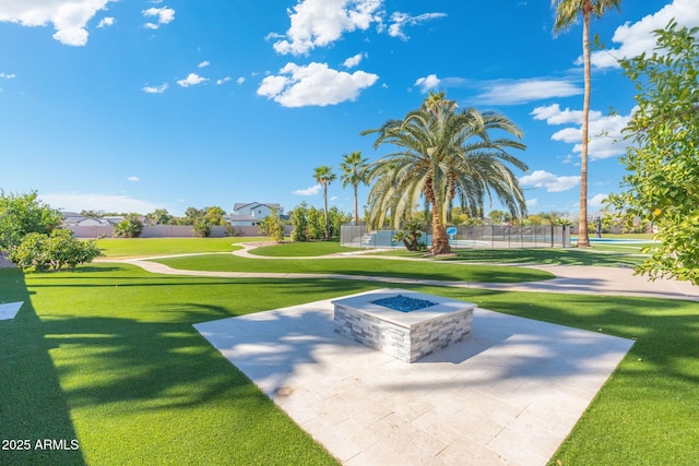 view of community with a lawn, a patio area, and an outdoor fire pit