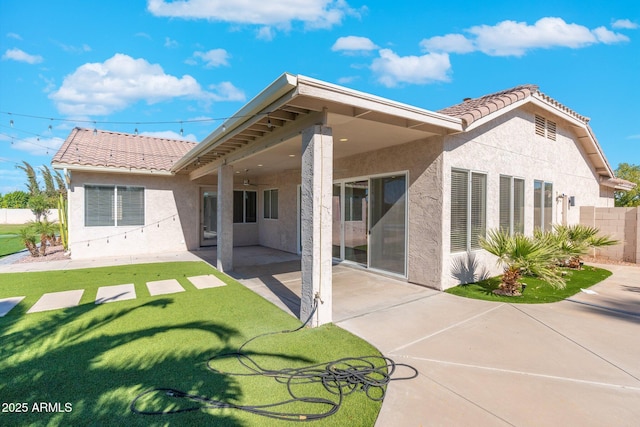 back of property featuring a lawn, a patio, and ceiling fan