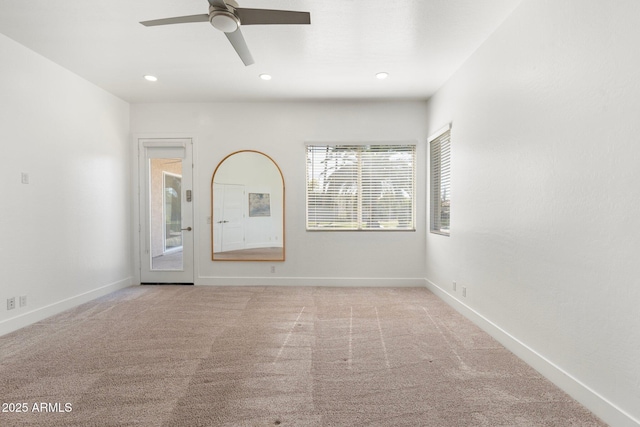 carpeted spare room featuring ceiling fan