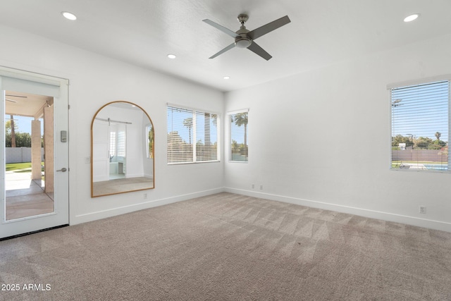 carpeted spare room with ceiling fan