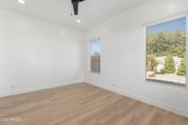 empty room with ceiling fan and light hardwood / wood-style floors