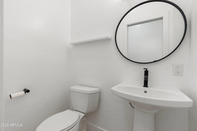 bathroom featuring sink and toilet