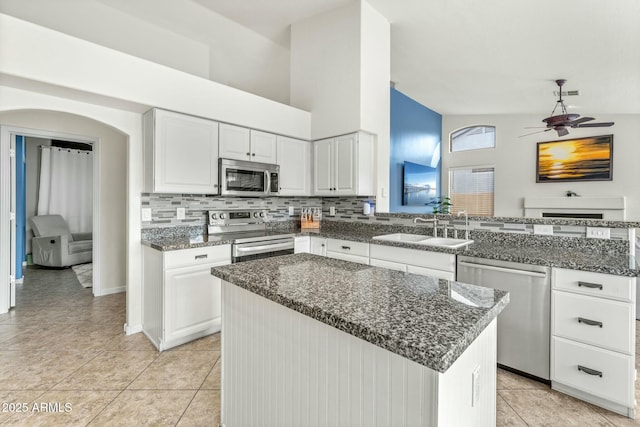 kitchen with a center island, appliances with stainless steel finishes, tasteful backsplash, sink, and white cabinets