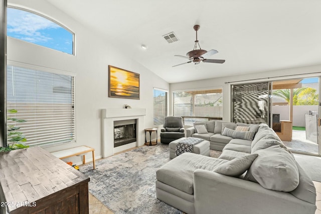 tiled living room featuring ceiling fan and lofted ceiling