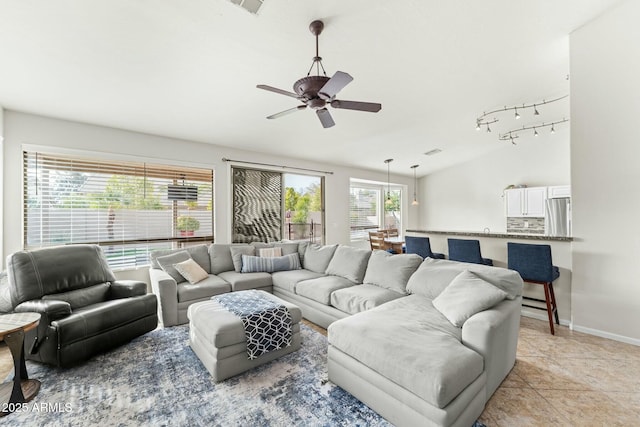 living room featuring ceiling fan, a wealth of natural light, and light tile patterned floors