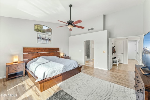 bedroom featuring light wood-type flooring, ceiling fan, and high vaulted ceiling