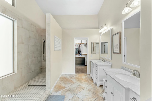 bathroom with a tile shower, tile patterned floors, and vanity