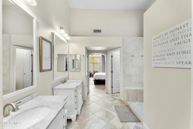 bathroom featuring tiled shower, tile patterned flooring, and vanity