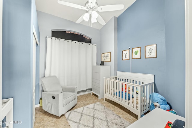 tiled bedroom featuring ceiling fan and a nursery area