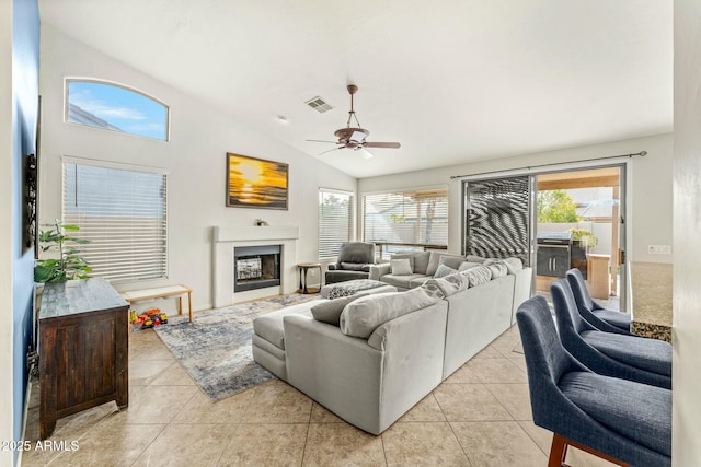 living room featuring ceiling fan, light tile patterned floors, and lofted ceiling