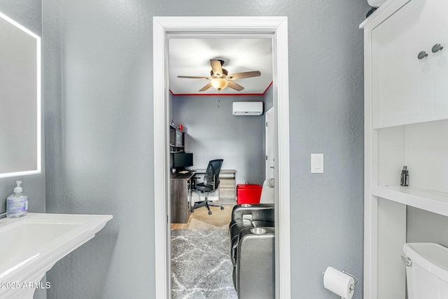 bathroom featuring ceiling fan, hardwood / wood-style flooring, toilet, and a wall unit AC