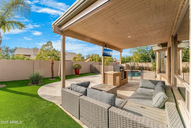 view of patio with area for grilling, a fenced in pool, an outdoor kitchen, and outdoor lounge area