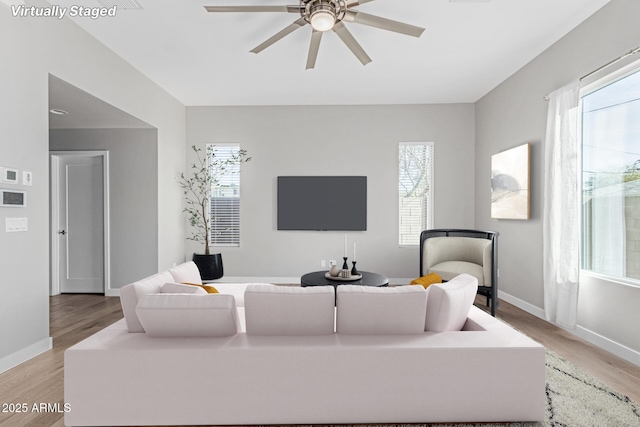 living room featuring light hardwood / wood-style floors and ceiling fan