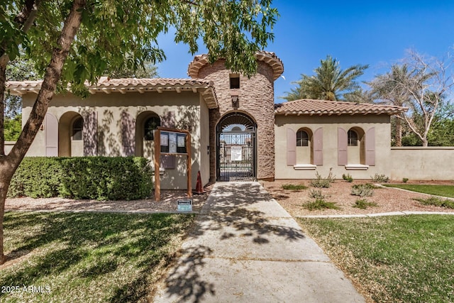 2631 S Sulley Dr Unit 104, Gilbert, AZ 85295 - mediterranean / spanish-style home featuring stucco siding, a tile roof, and a gate