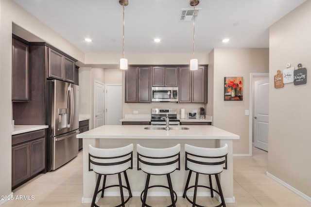2631 S Sulley Dr Unit 104, Gilbert, AZ 85295 - kitchen featuring appliances with stainless steel finishes, dark brown cabinetry, light countertops, a breakfast bar area, and recessed lighting