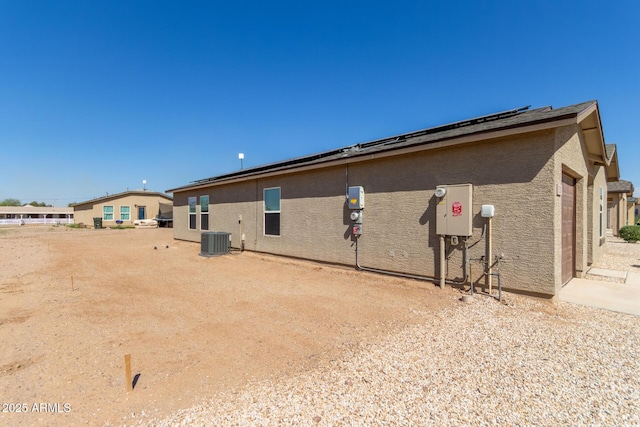 32024 N Redding St, Wittmann, AZ 85361 - view of side of home with roof mounted solar panels, cooling unit, a garage, and stucco siding