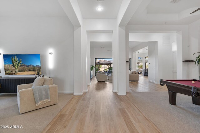 foyer entrance featuring pool table, a tray ceiling, and light hardwood / wood-style flooring