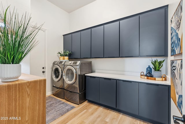 washroom featuring cabinets, washer and dryer, and light hardwood / wood-style floors