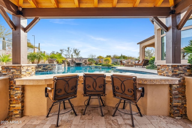 view of patio / terrace with pool water feature and an outdoor bar