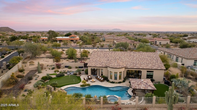 pool at dusk with a patio area