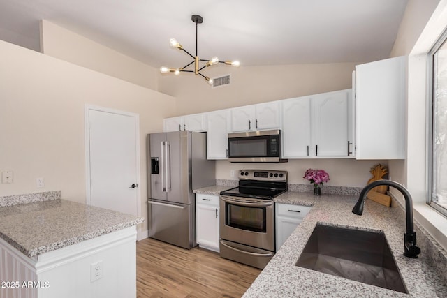 8103 E Dartmouth St, Mesa, AZ 85207 - kitchen with appliances with stainless steel finishes, a sink, a chandelier, white cabinets, and light wood finished floors