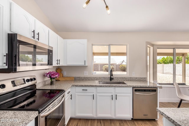 8103 E Dartmouth St, Mesa, AZ 85207 - kitchen with stainless steel appliances, a sink, white cabinets, and light wood-type flooring