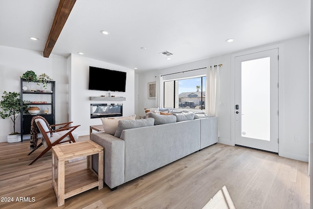 living room with beamed ceiling and light hardwood / wood-style floors