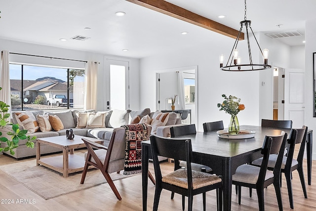 dining room with light hardwood / wood-style flooring, beamed ceiling, and a chandelier