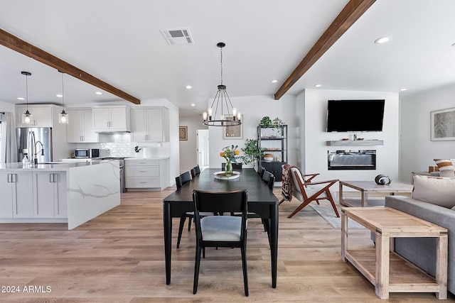 dining room featuring beamed ceiling, light hardwood / wood-style flooring, a notable chandelier, and sink