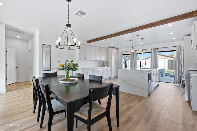 dining area with light hardwood / wood-style flooring, beamed ceiling, an inviting chandelier, and sink