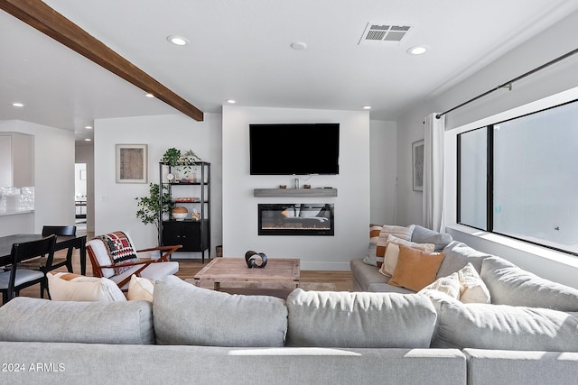 living room featuring beamed ceiling and hardwood / wood-style floors