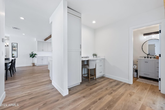 home office featuring light hardwood / wood-style floors and sink