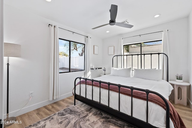 bedroom featuring light wood-type flooring, multiple windows, and ceiling fan