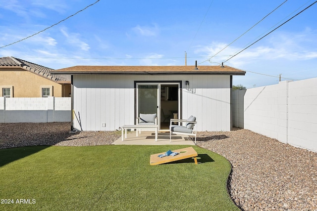 back of property with a lawn and a patio area