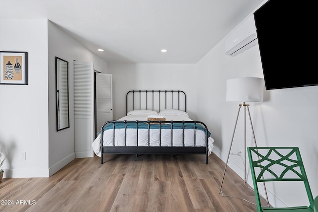 bedroom featuring an AC wall unit and wood-type flooring