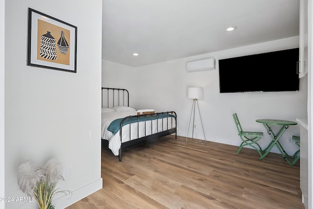 bedroom featuring a wall unit AC and wood-type flooring