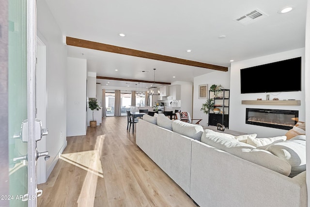 living room with beam ceiling and light wood-type flooring