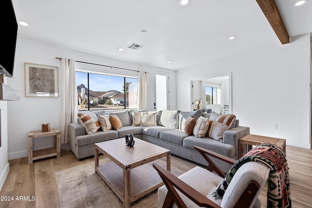 living room with beamed ceiling and light hardwood / wood-style floors