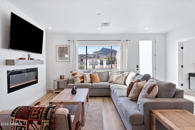 living room with a mountain view and light hardwood / wood-style flooring