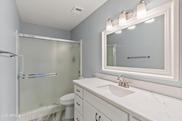 bathroom with toilet, a shower stall, visible vents, and vanity