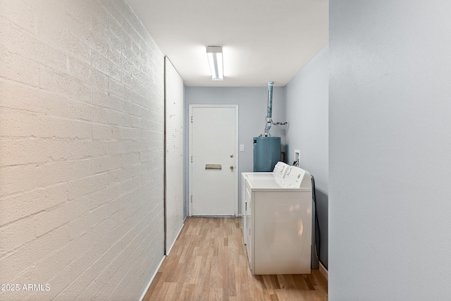 clothes washing area with light wood finished floors, gas water heater, and washing machine and clothes dryer