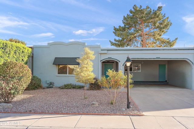 view of front of home with concrete driveway and stucco siding