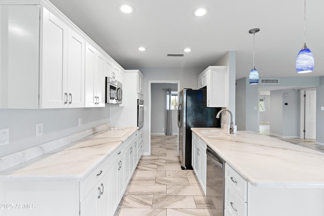 kitchen with stainless steel appliances, a peninsula, a sink, and visible vents