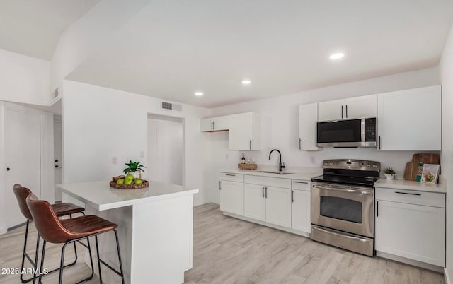 kitchen featuring white cabinetry, sink, a center island, and appliances with stainless steel finishes