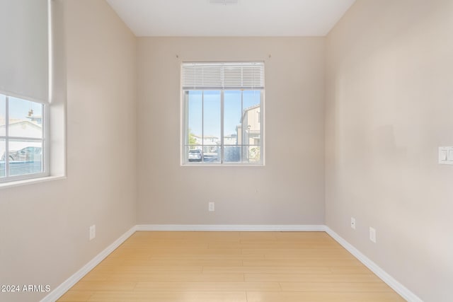 spare room featuring a wealth of natural light and light hardwood / wood-style floors