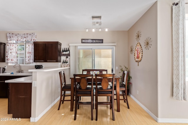 dining room featuring sink and light hardwood / wood-style floors