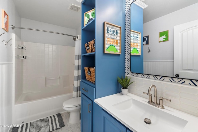 full bathroom featuring visible vents, toilet, shower / tub combo with curtain, wainscoting, and vanity