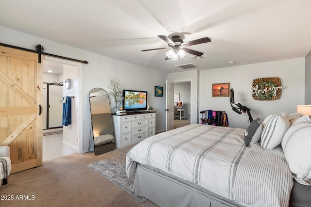 bedroom with a ceiling fan, a barn door, light colored carpet, and visible vents