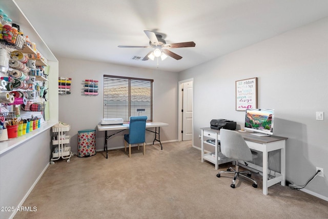 carpeted office space with baseboards and a ceiling fan