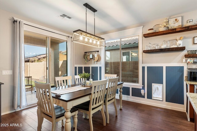 dining space featuring dark wood finished floors, visible vents, and baseboards